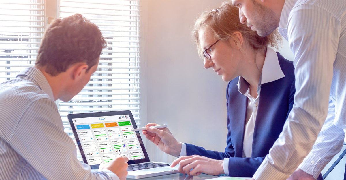 Team meets and reviews content on a laptop