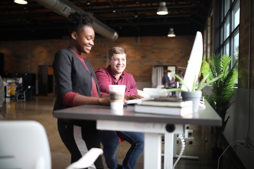 Two people looking at a desktop computer together